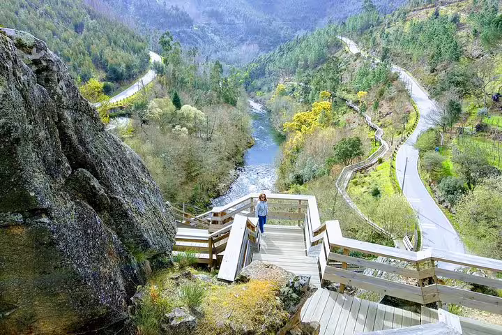 Scenic view of Paiva Walkways with a visitor enjoying the lush landscape and winding paths near Aveiro, Portugal.