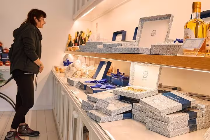 Tourist browsing gourmet products and gift boxes in a cozy shop near Paiva Walkways, offering local delicacies.
