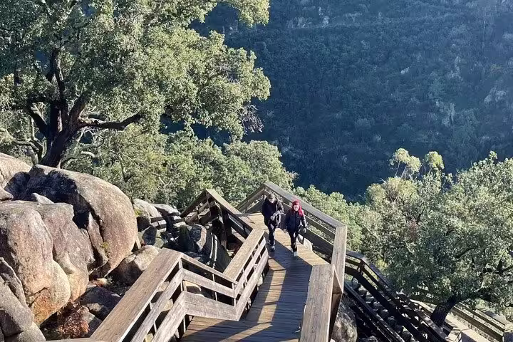 Visitors exploring scenic wooden pathways amidst rocky landscapes at Paiva Walkways.