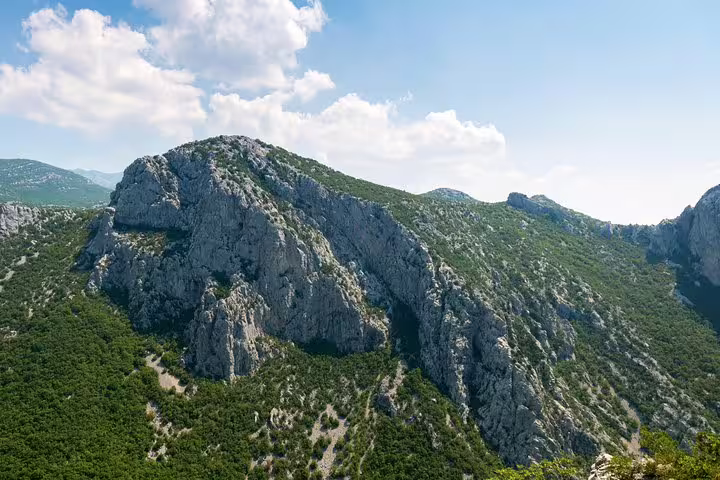 Rocky Velebit mountain ridge above green forests in Paklenica National Park, Croatia scenic viewpoint