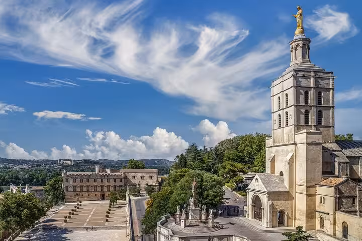 Stunning view of the Palais des Papes in Avignon with its towering architecture and picturesque landscape on a bright day.