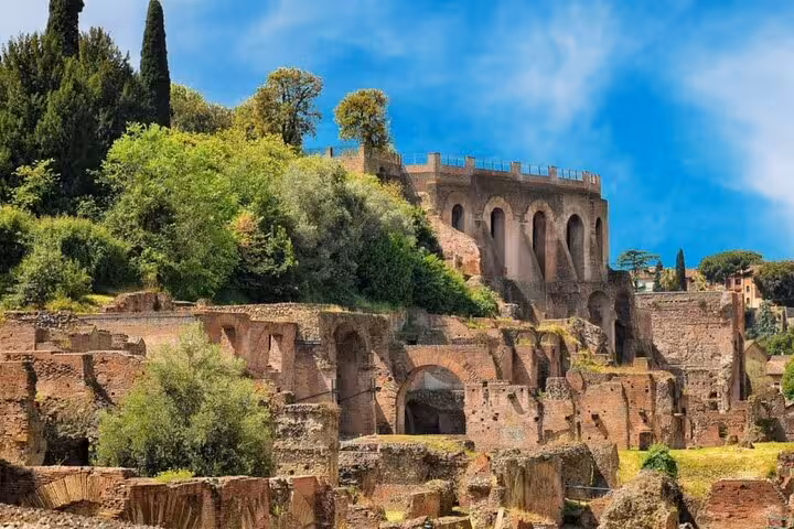 Lush greenery surrounding the ancient ruins of Palatine Hill, showcasing historic architecture in Rome.