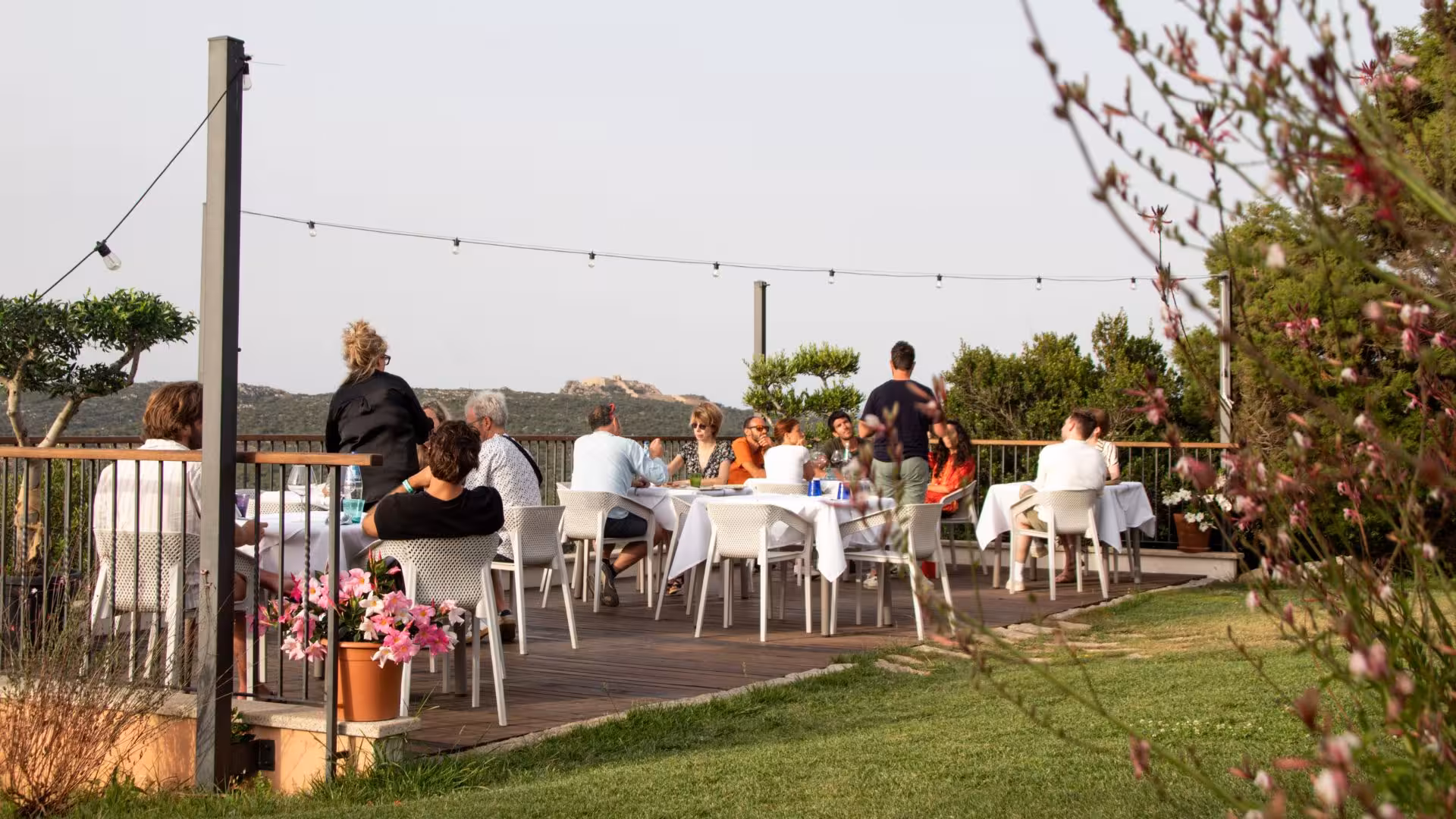 Guests dining outdoors at Gallura winery in Palau, enjoying panoramic views and wine tasting.