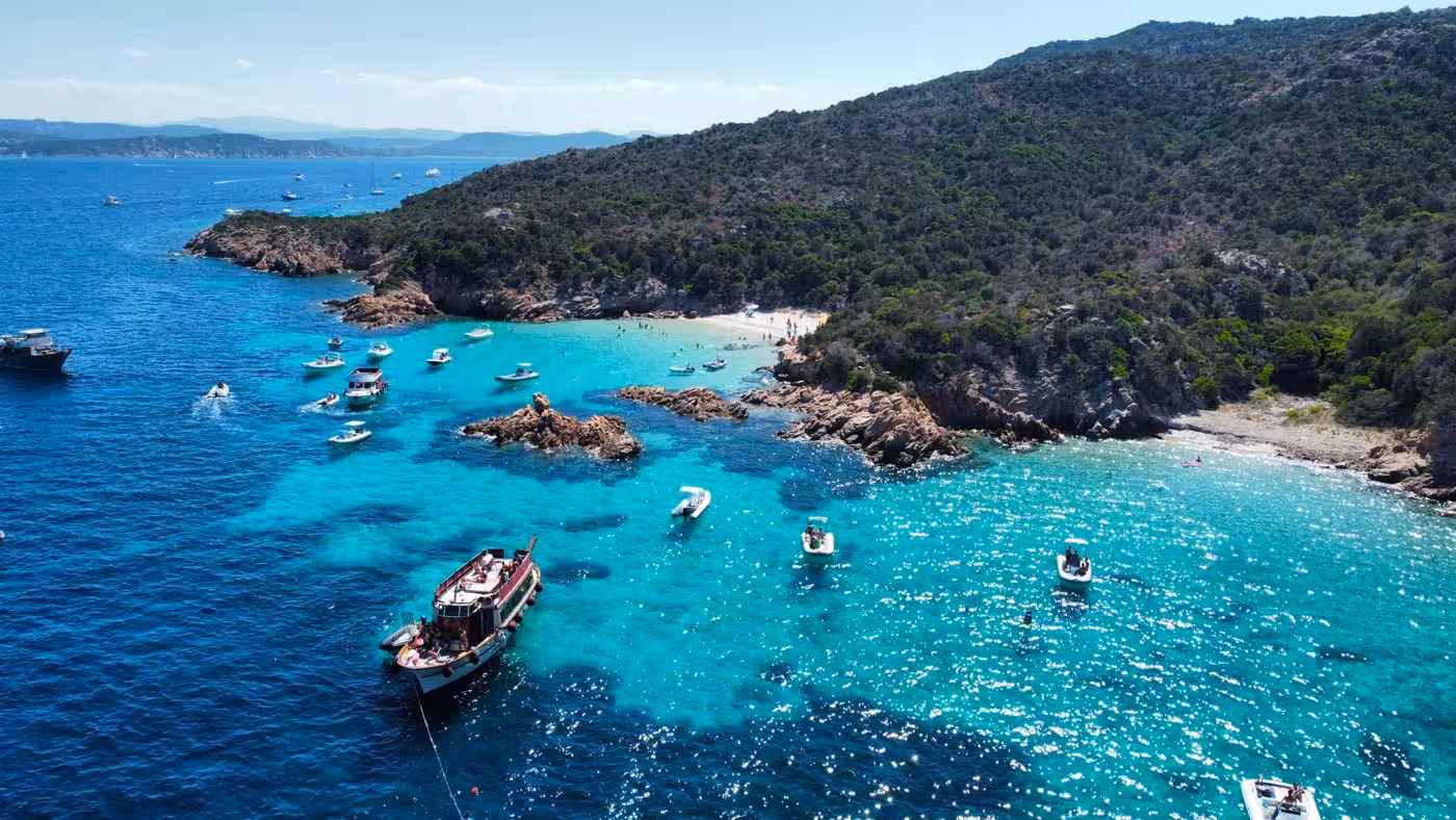 Aerial view of La Maddalena Archipelago with motorboats in turquoise waters, perfect for a scenic boat tour from Palau.