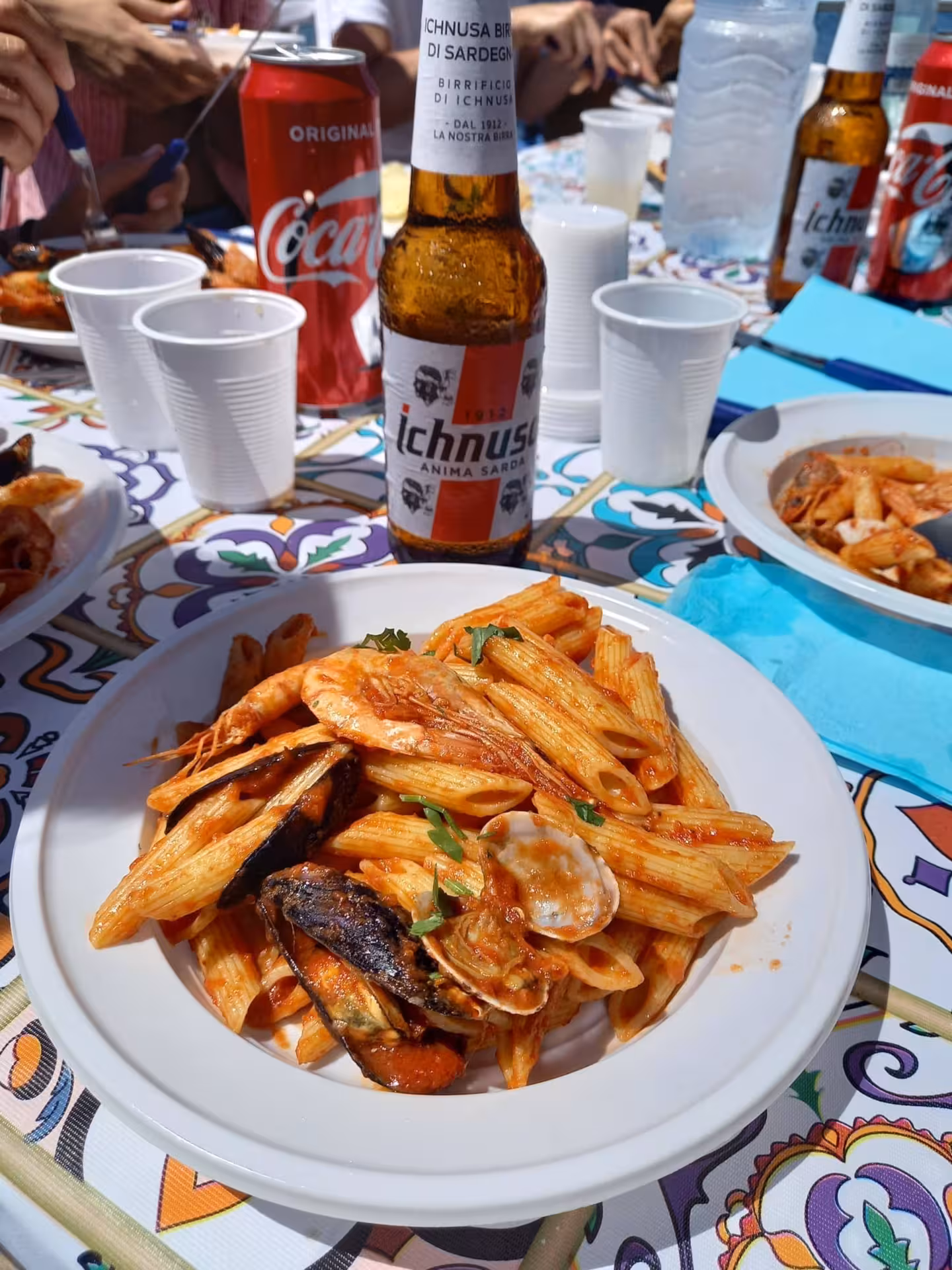 Savor delicious seafood pasta and Sardinian beer on a scenic La Maddalena Archipelago boat trip from Palau.