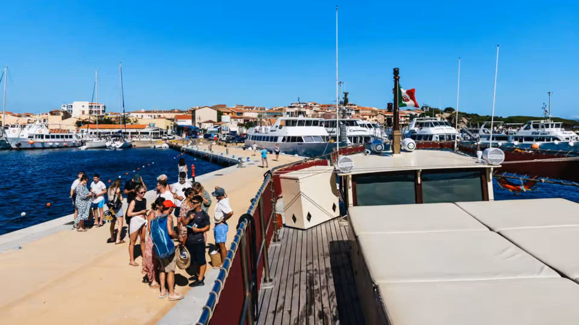 Tourists gather at the pier in Palau for a motorboat tour of the scenic La Maddalena Archipelago.
