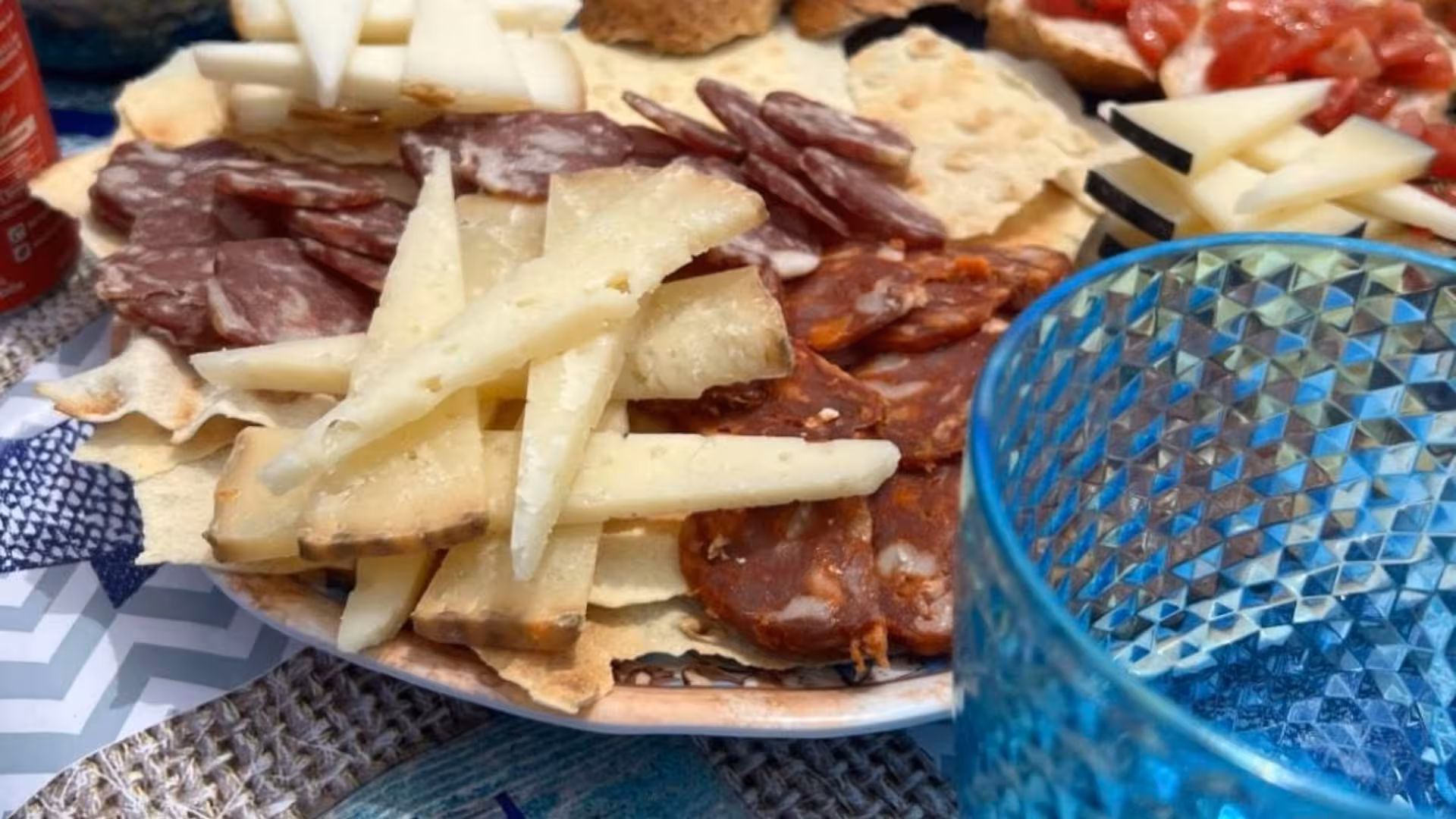 Platter of cured meats and cheeses on a sailing excursion in La Maddalena, highlighting local flavors from Palau.