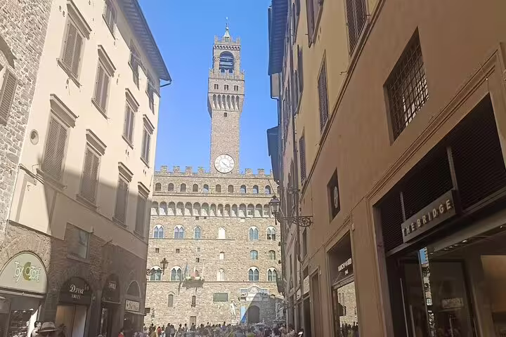 Historic Palazzo Vecchio clock tower framed by narrow Renaissance streets on a Florence shore excursion from Livorno