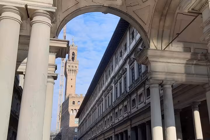 The iconic Palazzo Vecchio seen through the arches of the Uffizi Gallery, capturing Florence's Renaissance charm.