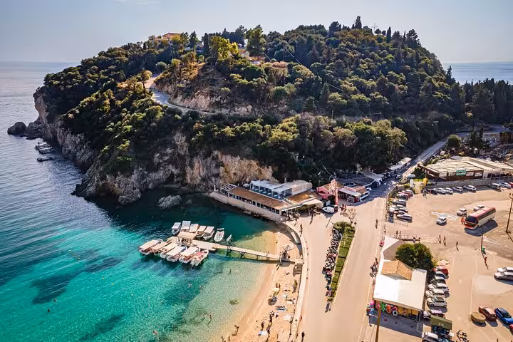 Sunny Paleokastritsa beach and turquoise bay in Corfu, featured stop on a private tour with local tastings