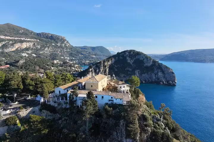 Aerial view of Corfu’s Paleokastritsa monastery on a cliff above turquoise Ionian Sea bays