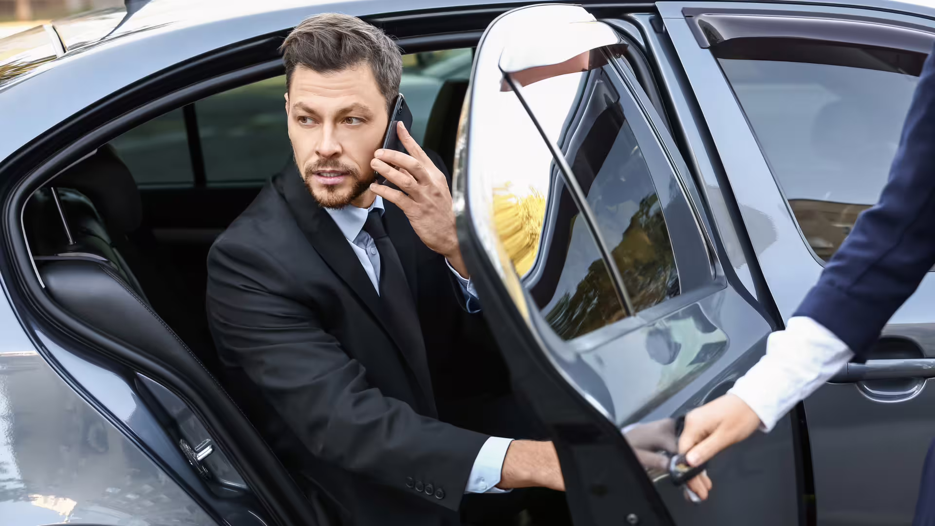 Business traveler using private chauffeur service from Palermo airport, stepping from luxury car toward Hotel Principe di Villafranca