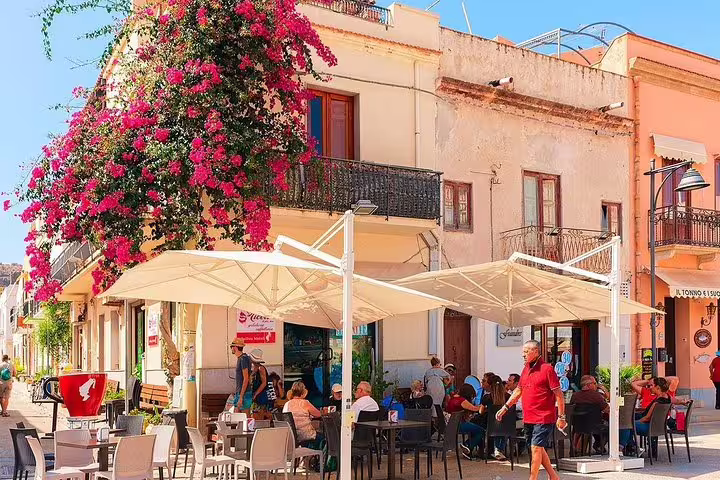 Outdoor café with flowering bougainvillea in sunny San Vito Lo Capo old town, arrival point of Palermo Airport private transfer