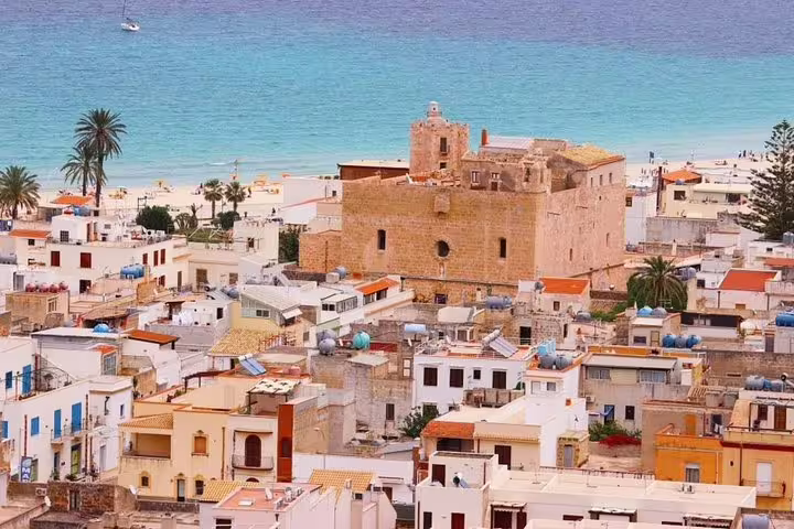 Historic center of San Vito Lo Capo with seaside church and colorful houses near the beach served by Palermo Airport transfer