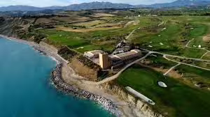 Aerial view of Verdura Resort Sciacca on the Sicilian coast, surrounded by golf courses and turquoise Mediterranean sea