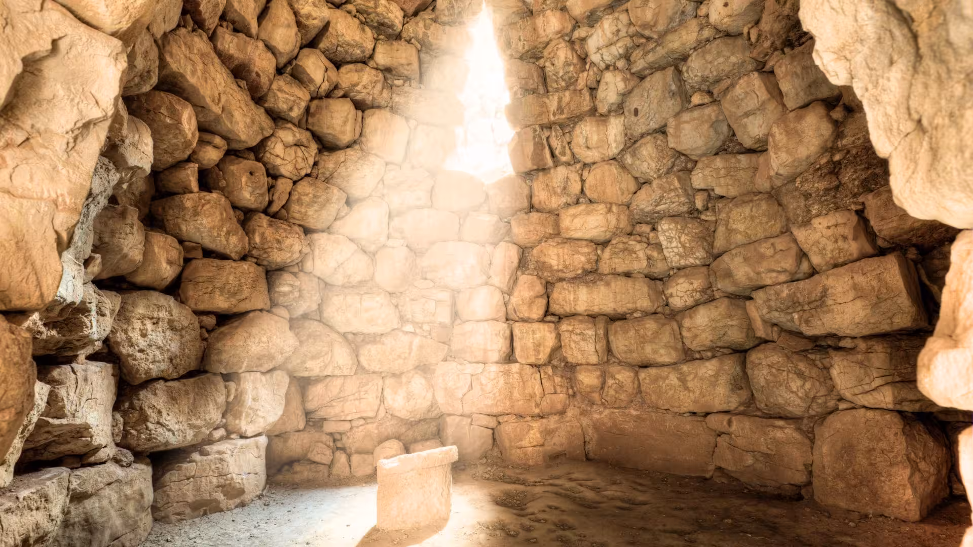 Sunlight pours into the stone interior of Palmavera nuraghe, highlighting its ancient architectural beauty.