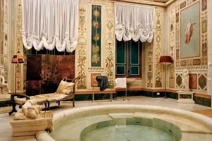 Opulent room in Pamphilj Gallery showcasing a lavish bath area with classic furnishings and detailed wall art.