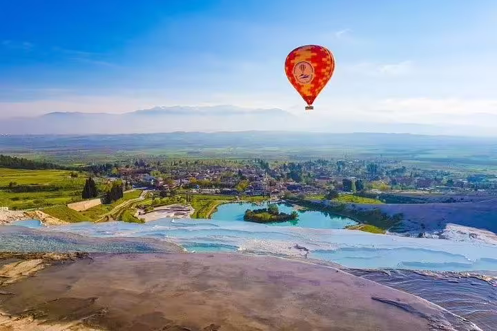 Experience a breathtaking hot air balloon ride over Pamukkale's travertine terraces on a day tour from Istanbul.