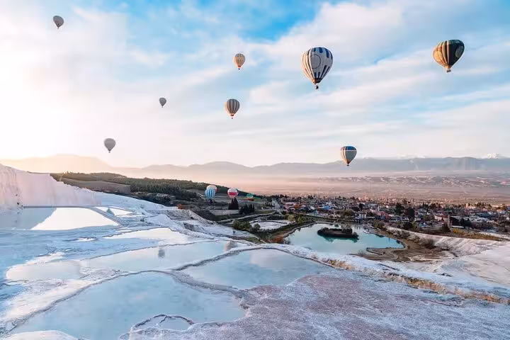 Pamukkale hot air balloon flight over white travertine terraces and thermal pools at sunrise in Turkey
