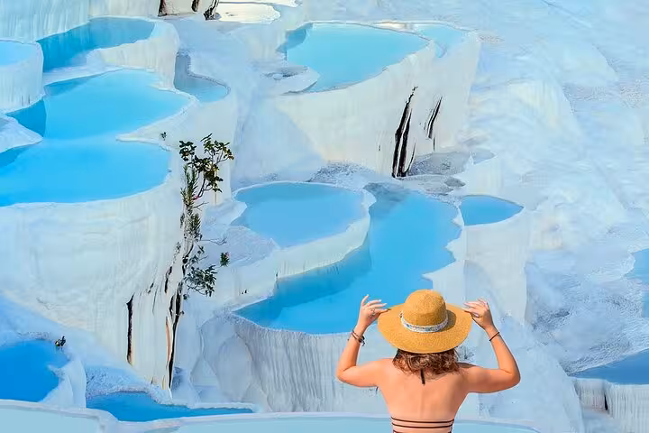 Traveler viewing turquoise Pamukkale thermal pools and white travertines on full-day tour from Selcuk Kusadasi