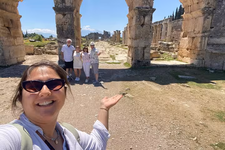 Visitors posing by the monumental gate at Hierapolis ruins on a private Pamukkale tour from Denizli Airport