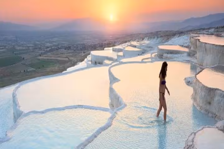 Sunset at Pamukkale travertine terraces with visitor in thermal pools, Denizli Turkey day tour highlight