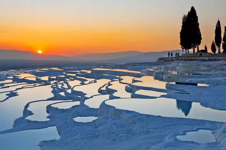 Sunset over Pamukkale travertine terraces and thermal pools on a full-day tour from Selcuk and Kusadasi
