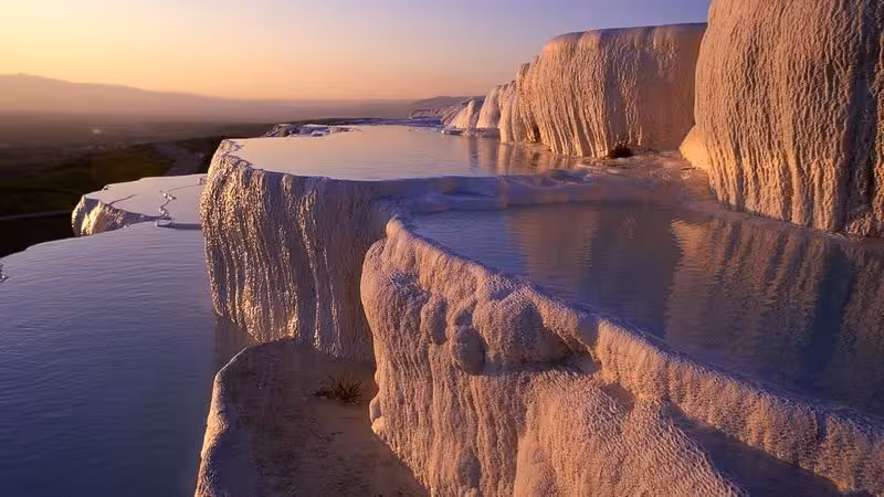 Sunset over Pamukkale travertine terraces and thermal pools, highlight of 7-day Istanbul Cappadocia Ephesus tour
