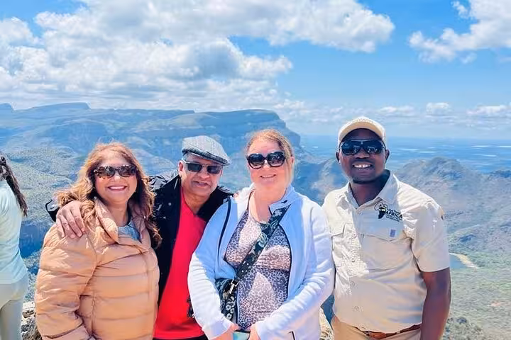 Group enjoying a scenic view atop a mountain during the Panorama Guided Experience tour on a sunny day.
