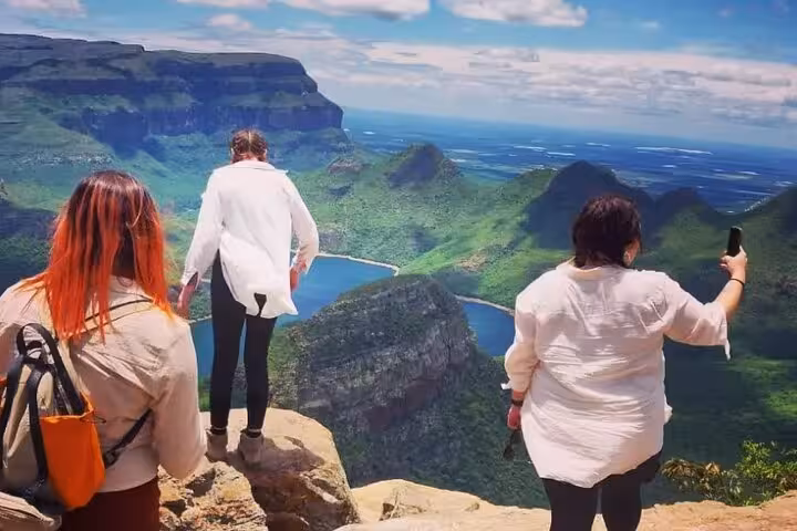 Tourists capturing breathtaking views of the verdant mountains and azure lakes on the Panorama Guided Experience.