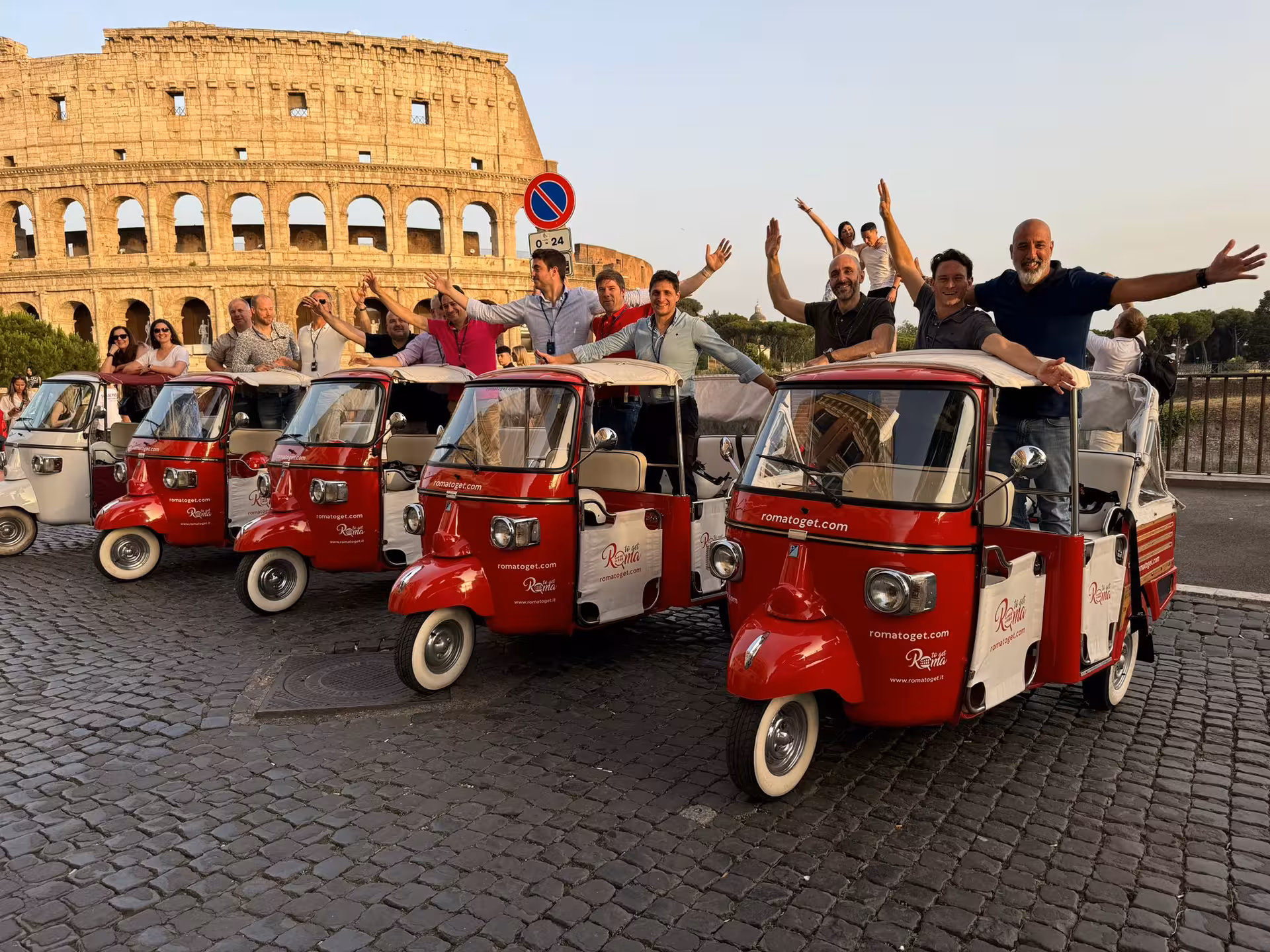 Tourists enjoy a vibrant tuk-tuk ride with the iconic Colosseum backdrop during the Pantheon Combo Tour in Rome.