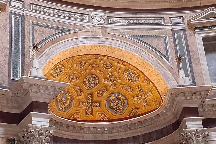 Close-up of the Pantheon’s ornate golden ceiling with elaborate geometric designs and artistic embellishments.