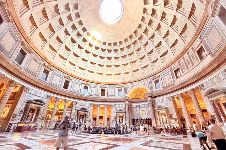 Tourists admire the majestic dome and intricate interior of Rome's Pantheon, highlighting its architectural brilliance.