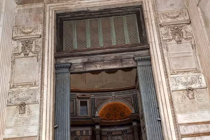 Entrance of the Pantheon in Rome showcasing intricate architectural details and historical inscriptions.