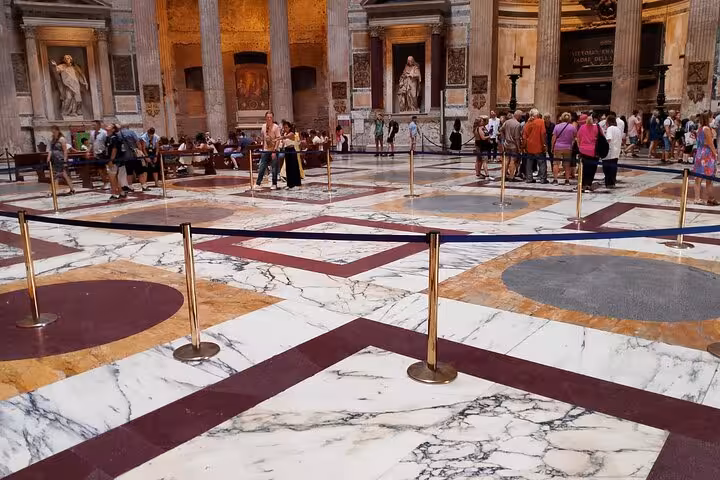 Visitors explore the Pantheon's grand marble interior with columns and artwork, accessed with a digital audio guide.