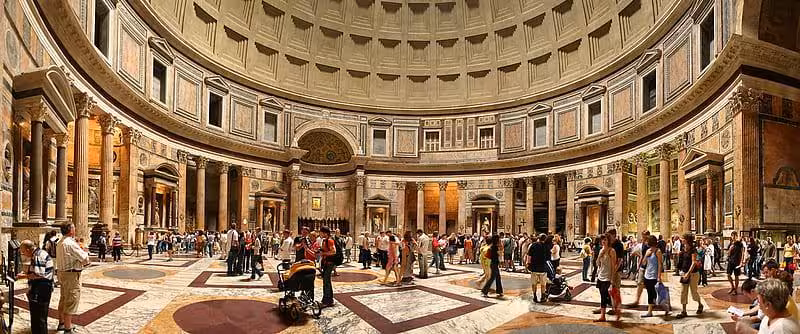 Visitors explore the grand interior of the Pantheon in Rome, highlighting its architectural magnificence and historical allure.