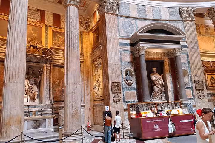 Close-up of the Pantheon's interior in Rome with detailed sculptures, marble columns, and decorative artwork.