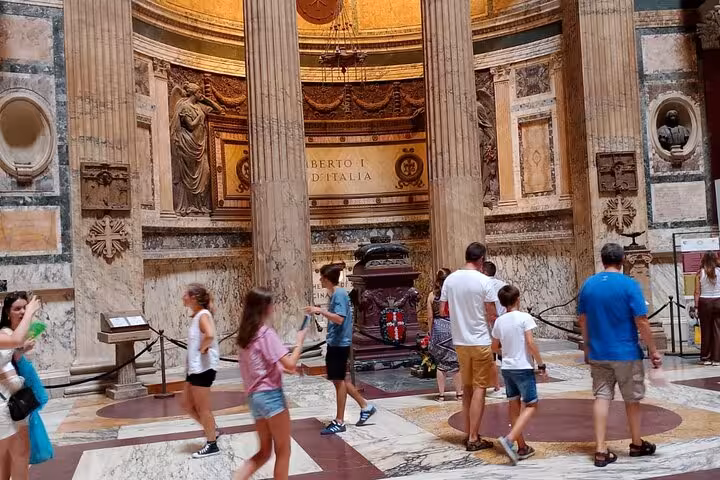 Visitors admire the Pantheon's ornate interior, highlighting intricate columns and sculptures in this iconic Roman landmark.