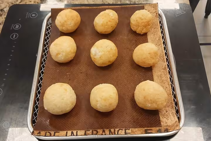 Freshly baked pão de queijo on a baking tray, showcasing the culinary delights of Rio's cooking tour.
