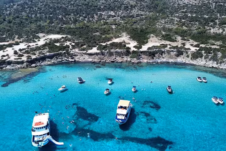 Aerial view of Akamas Blue Lagoon near Paphos with tour boats anchored for swimming, bus and boat transfer