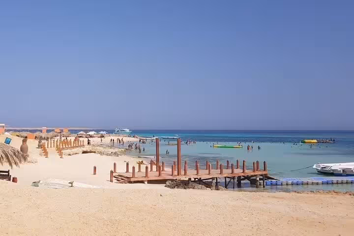 Wide Paradise Island beach with jetty and calm Red Sea lagoon on full-day VIP snorkeling boat trip from Hurghada
