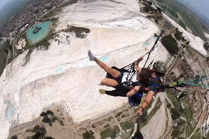 Paragliding over Pamukkale white travertines on a private tour from Denizli Airport with aerial views