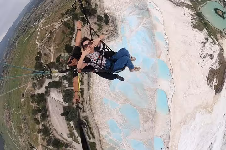 Paragliding over Pamukkale white travertines and turquoise pools on a private tour from Kusadasi or Selcuk