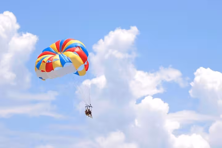 Colorful parasailing canopy soaring high near Sharm El Sheikh, Red Sea tour with private hotel transfer