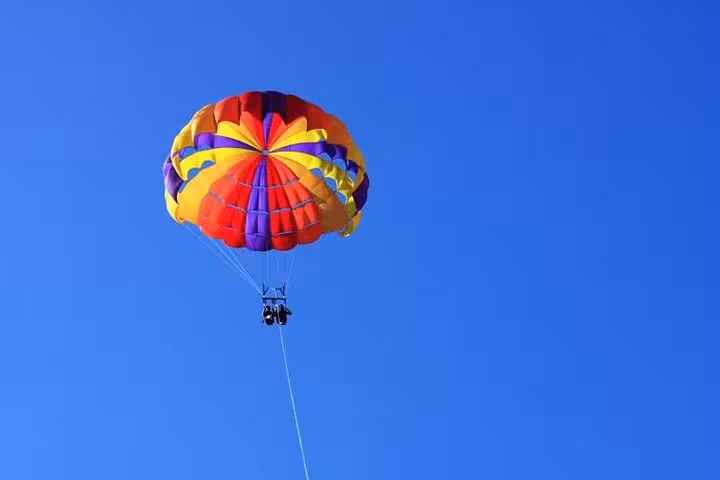 Colorful parasailing canopy soaring over Hurghada, Red Sea adventure with private transfer included
