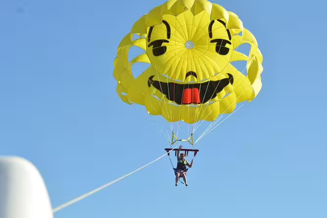 Parasailing in Hurghada with yellow smiley canopy, flying above the Red Sea on a thrilling water sports excursion