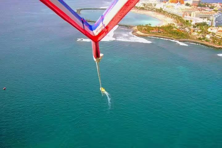 Aerial view of parasailing over turquoise waters near Santa Cruz de Tenerife with stunning coastal scenery.