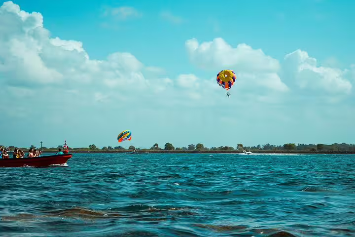 Wide view of parasailing in Sharm El Sheikh over the Red Sea, boats and colorful chutes on horizon