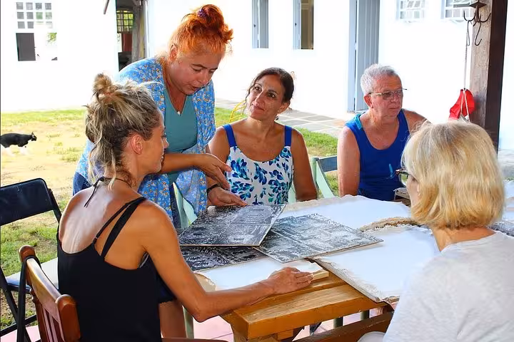 Instructor guides participants through a painting technique at the Paraty Art Experience class outdoors.