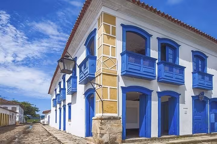 Charming colonial architecture with vibrant blue balconies under a clear sky in the historic center of Paraty, Brazil.